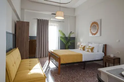 a bedroom with a bed and a couch at Fyllianos Apartments in Plátanos