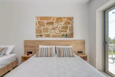 a bedroom with a bed and a stone wall at Elafonisi Pearl in Elafonisi