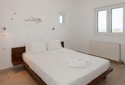 a white bedroom with a large bed with white sheets at Myrto Villa heated pool in Kato Daratso