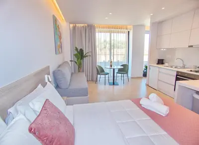 a bedroom with a bed and a kitchen with a table at Melina Apartments Sea & City in Chania Town