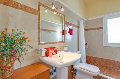 a bathroom with a sink and a toilet and a mirror at Villa Clio, with Mountain view in Arménoi