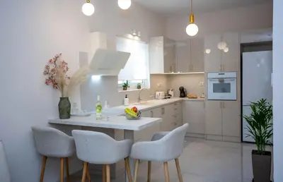 a white kitchen with a table and some chairs at Maira City House in Chania Town