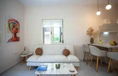 a living room with a white couch and a table at Maira City House in Chania Town