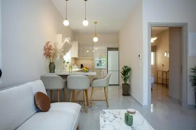 a living room and kitchen with a couch and a table at Maira City House in Chania Town