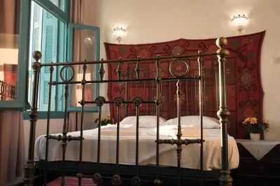 a bedroom with a metal bed with a red head board at Pension Nora in Chania Town
