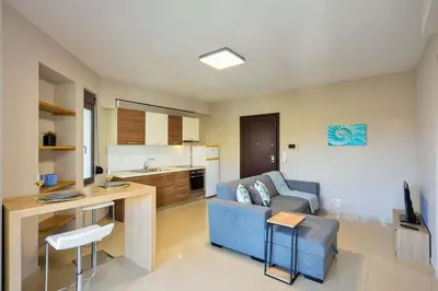 a living room with a blue couch and a kitchen at Marena Apartments in Chania Town