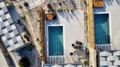 an overhead view of two swimming pools in a building at LIViT Condo Elafonisi in Agios Padeleimon