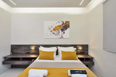 a bedroom with a large bed with yellow pillows at Artemis Luxury Home in Chania Town
