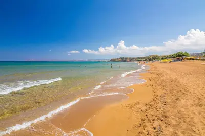 a beach with people swimming in the water at Nektar Luxury Apartment in Stalos