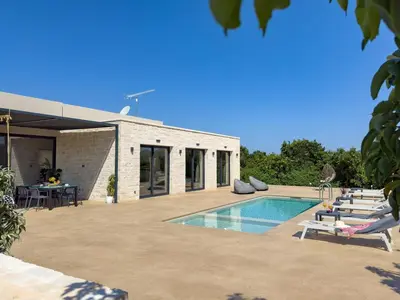 a swimming pool with lounge chairs next to a house at PanStel - Villa Aurora with private pool jacuzzi in Ayiá