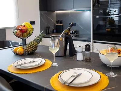 a kitchen counter with a table with plates and wine glasses at PanStel - Villa Aurora with private pool jacuzzi in Ayiá