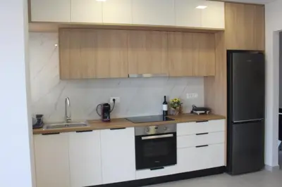a kitchen with white cabinets and a black refrigerator at MC Luxury Living in Chania Town