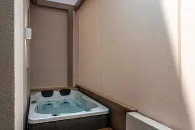 a small bathroom with a bath tub in the corner at Devina Residence 2025 , Luxury City Jacuzzi Apartment in Chania Town