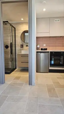 a kitchen with stainless steel appliances and a tile floor at Reflections Apartments in Stalos