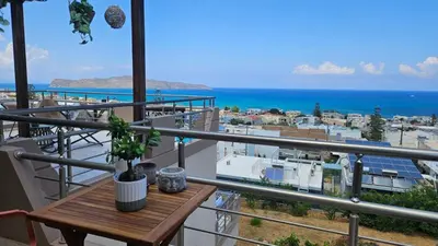 a balcony with a table and a view of the ocean at Reflections Apartments in Stalos