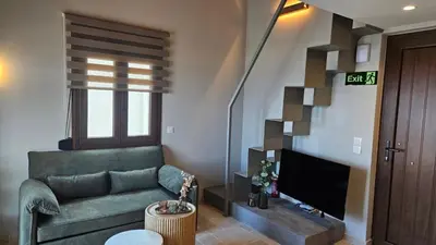 a living room with a green couch and a television at Reflections Apartments in Stalos