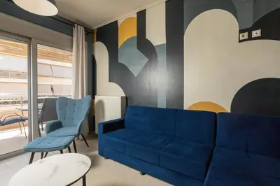 a living room with a blue couch and chairs at Zen City Beach Apartment in Chania Town