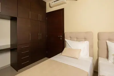 a small bedroom with a bed and a cabinet at Zen City Beach Apartment in Chania Town