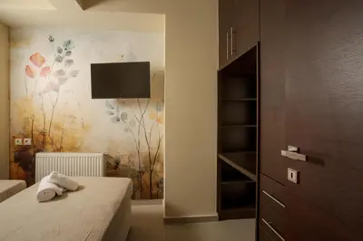 a bedroom with a bed and a tv on the wall at Zen City Beach Apartment in Chania Town
