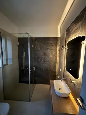a bathroom with a sink and a glass shower at Nea Chora seaside suites in Chania Town