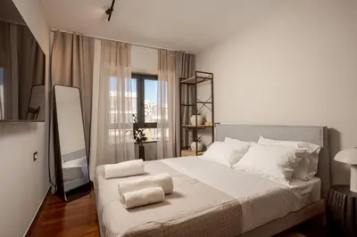 a bedroom with a large bed with white sheets and pillows at Demmi Central 2BR Designer Apt in Chania Town