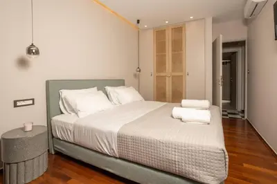 a bedroom with a large bed with white sheets and pillows at Demmi Central 2BR Designer Apt in Chania Town