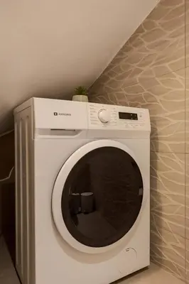 a white washing machine sitting in a room at Demmi Central 2BR Designer Apt in Chania Town
