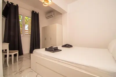 a white bedroom with a bed and a window at Casa calma! in Kountoura Selino