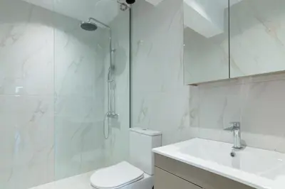 a bathroom with a shower and a toilet and a sink at Edward Luxury Suites in Chania Town
