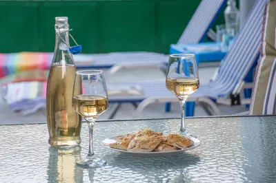 two glasses of wine and a plate of food on a table at Depi's Home in Kissamos