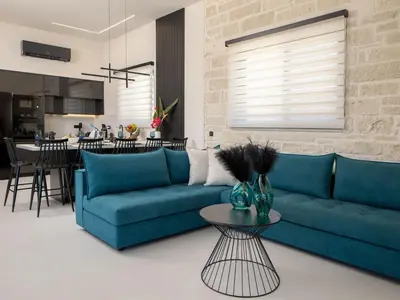 a living room with a blue couch and a table at PanStel - Villa Solene with private pool in Ayiá