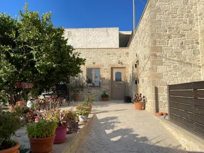 a stone building with potted plants on the sidewalk at Casa Maria in Gramvousá