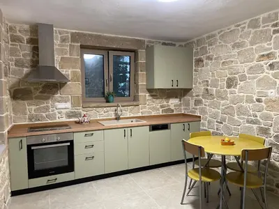 a kitchen with white cabinets and a yellow table at Casa Maria in Gramvousá