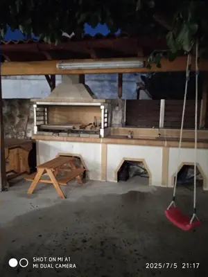 a table with a bench and a pizza oven at Villa Makyva in Kámboi