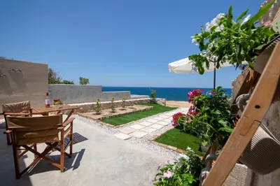 a patio with a table and chairs and the ocean at The Seaside Nest in Chania Town