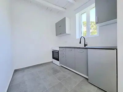 a kitchen with white walls and stainless steel appliances at Suites with Shared Garden Sougia in Moní