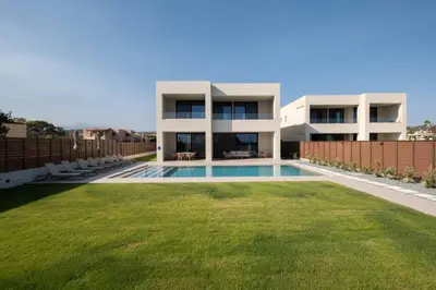 a house with a swimming pool in front of a yard at Gemini Villas Chania - Calma & Siesta in Maleme