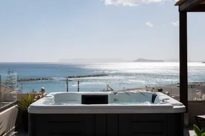 a hot tub on a balcony with a view of the ocean at See2sea Cozy Apartments in Kolymvari