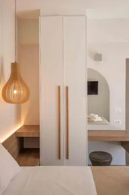 a white cabinet in a bedroom with a mirror at See2sea Cozy Apartments in Kolymvari