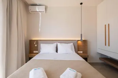 a bedroom with a bed with two white towels on it at See2sea Cozy Apartments in Kolymvari