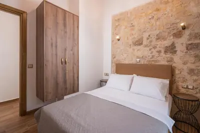 a bedroom with a large bed and a wooden cabinet at Stella's Traditional House Near the City in SFakianalíon