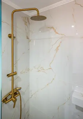a shower in a bathroom with white marble at Stella's Traditional House Near the City in SFakianalíon