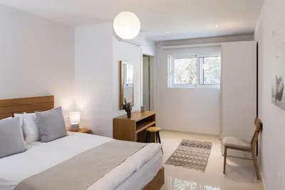 a bedroom with a bed and a desk and a window at Falasarna Seafront House I 50m to the Beach in Kavoúsion
