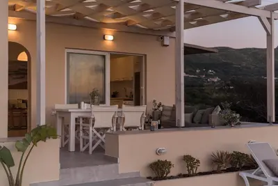 a house with a balcony with a table and chairs at Falasarna Seafront House I 50m to the Beach in Kavoúsion