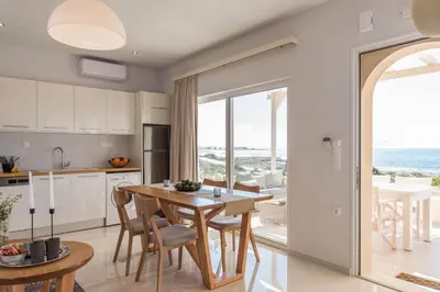 a kitchen and dining room with a table and chairs at Falasarna Seafront House I 50m to the Beach in Kavoúsion