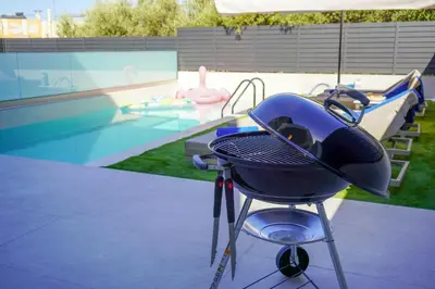 a barbecue grill sitting next to a swimming pool at Katakis Afroditi-Athina in Agios Onoufrios