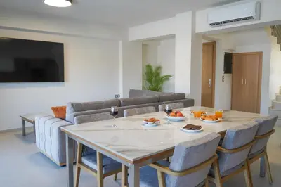a living room with a table and chairs and a couch at Katakis Afroditi-Athina in Agios Onoufrios