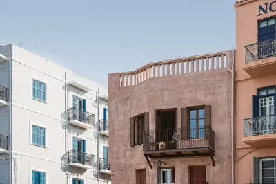 an old building with balconies in a city at Evrima High End Residence in Chania Town