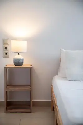 a bedroom with a bed and a lamp on a night stand at Light House Chania - 5 Min to Beach and Free Parking in Chania Town