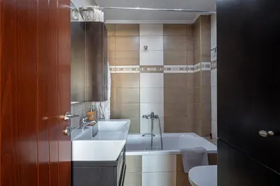 a bathroom with a sink and a bath tub at Light House Chania - 5 Min to Beach and Free Parking in Chania Town